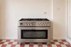A stainless steel stove with four burners and a digital clock. - Cozy Flat with Rooftop in the Heart of Valletta (Valletta)