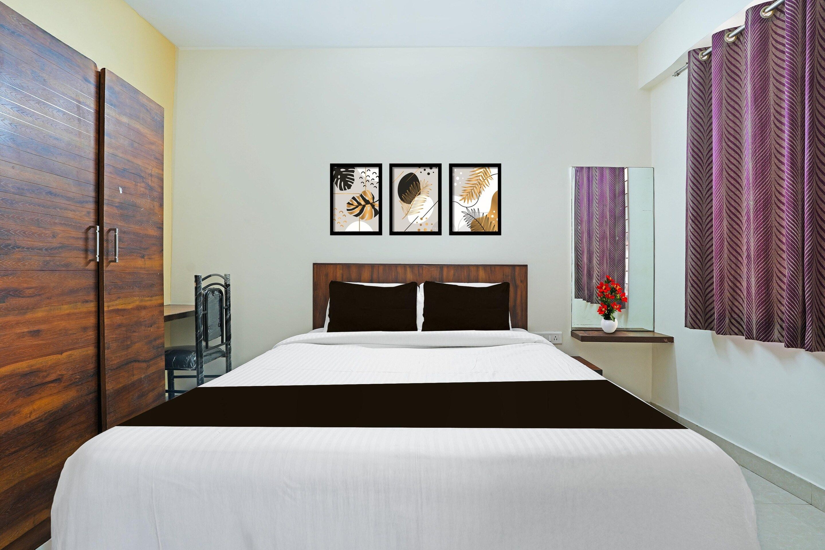A bedroom with a bed, a wardrobe, a nightstand with a vase, and a mirror.