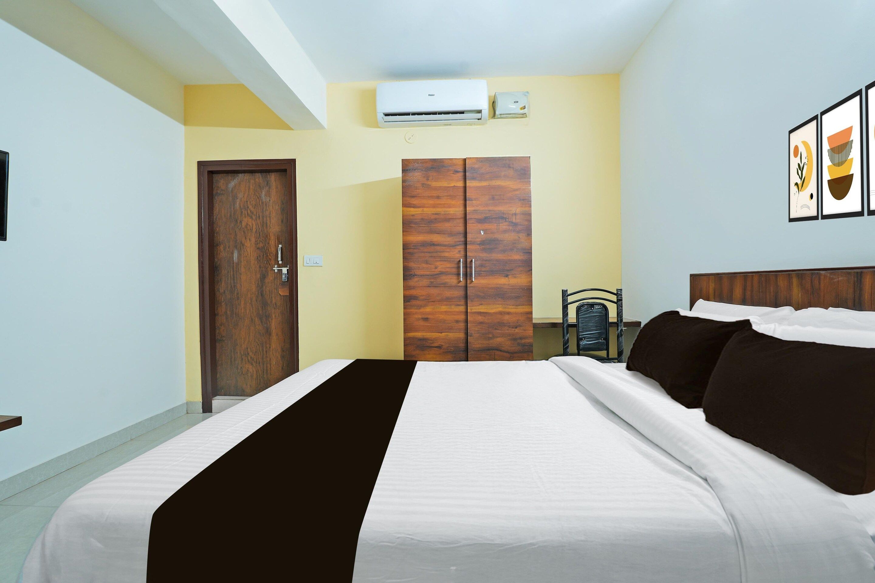Habitación de hotel con cama, armario y equipo de aire acondicionado.