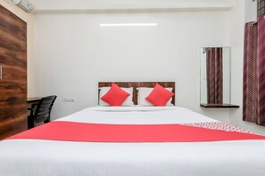 Ein Hotelzimmer mit einem Bett, einem Schreibtisch und einem Spiegel.