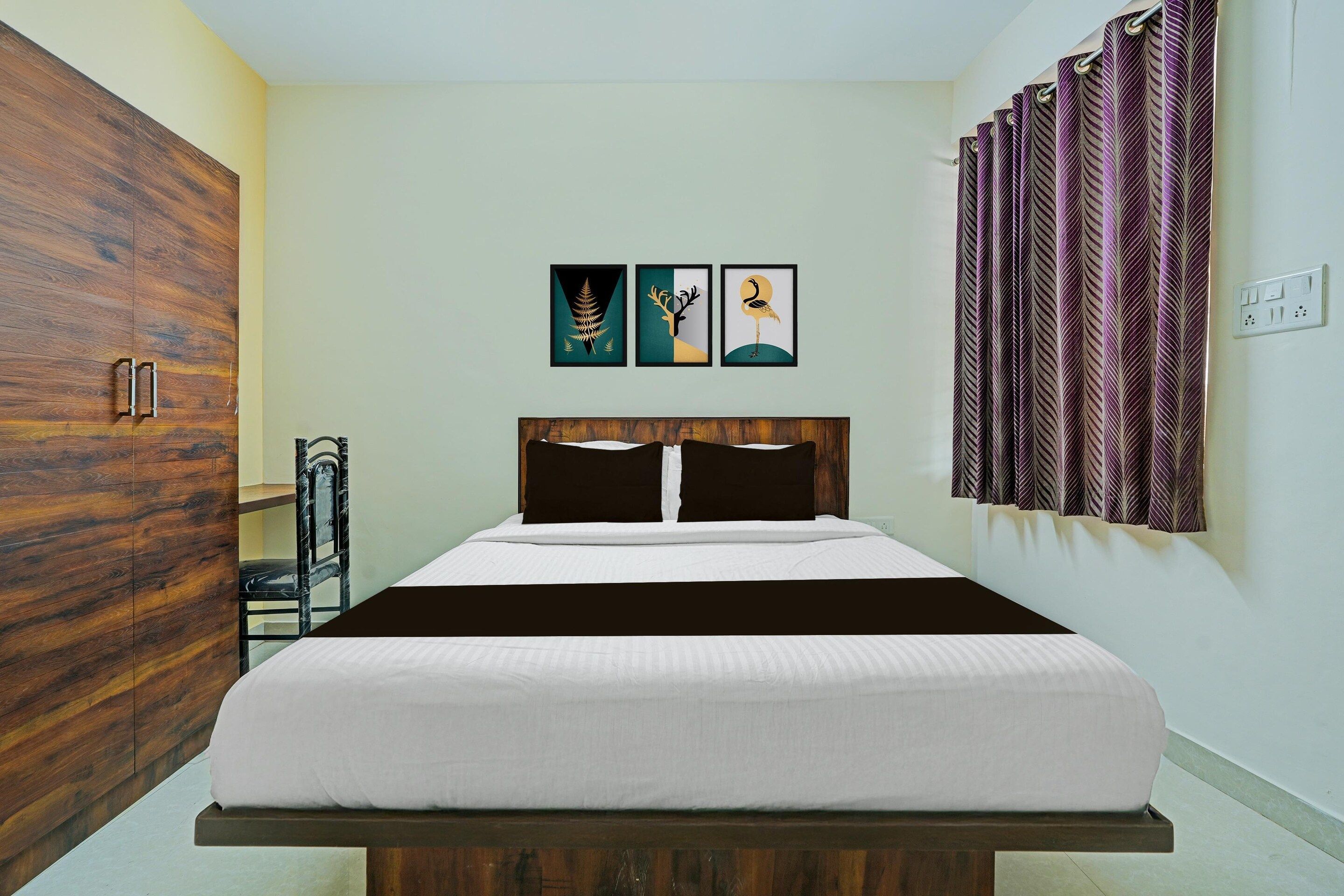 A bedroom with a bed, wardrobe, and artwork on the wall.