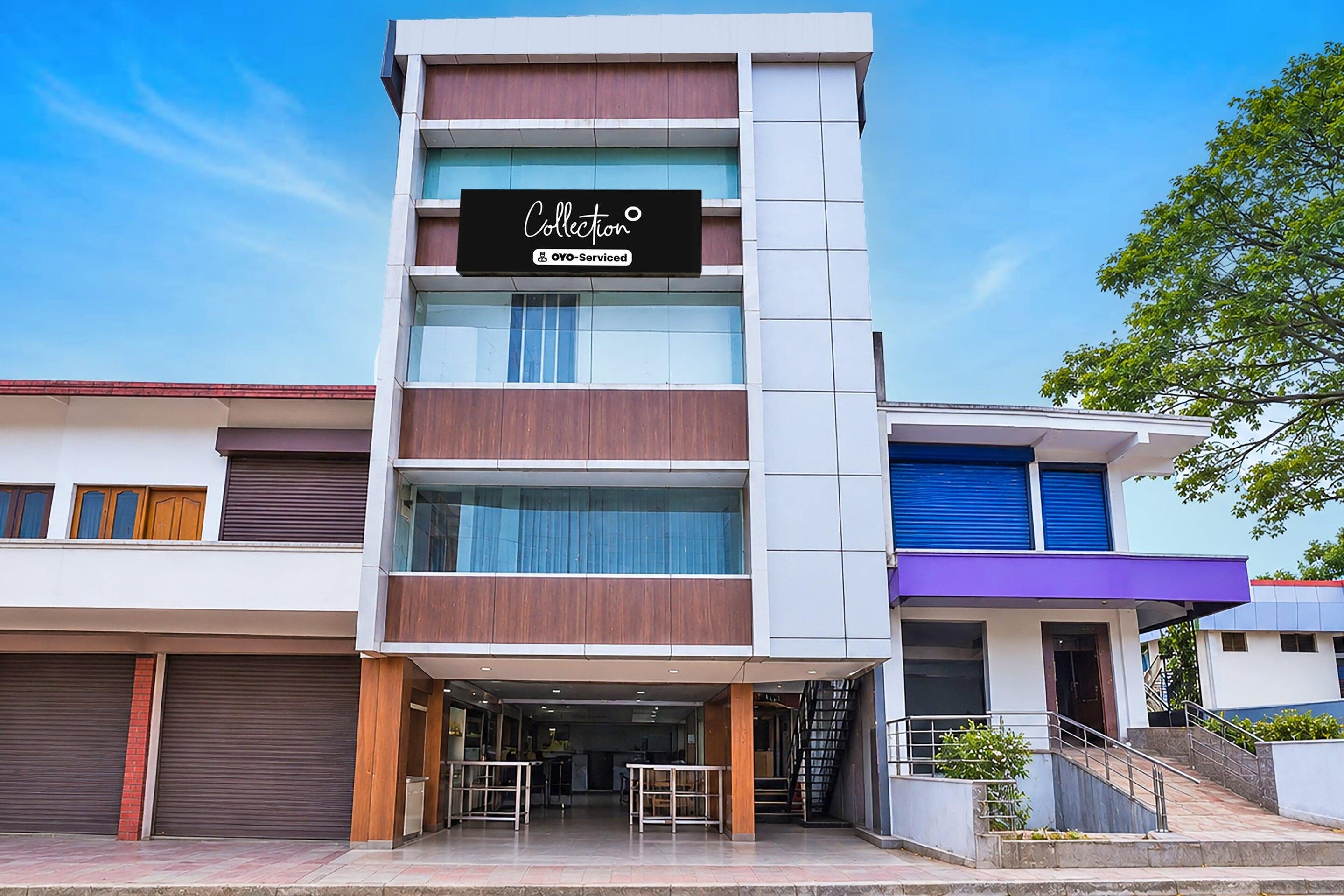 A multi-story building with a sign reading 'Collection OYO-Serviced'.
