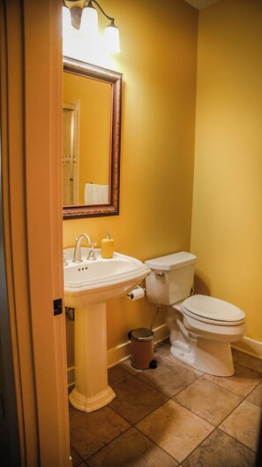 Ein Badezimmer mit einem weißen Waschbecken, einer Toilette und einem Mülleimer.