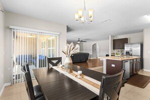 A modern kitchen with a dining area, a ceiling fan, and a view to the outside. - Waterfront 4-bedroom luxury pool home (Winter Haven)