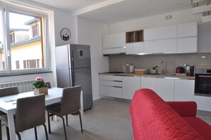 Eine moderne Küche mit weißen Schränken, einem eingebauten Ofen und einem Kühlschrank.