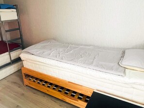 Ein Einzelbett mit Holzrahmen und Matratze.