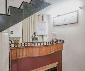 Una escalera con barandilla de madera y un calendario colgado en la pared.