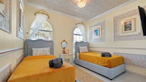 Camera d'albergo con due letti, un lampadario e pannelli decorativi a parete.