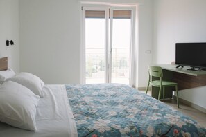 A bedroom with a bed, a desk, a chair, and a television. - Aetnamare: A 360° View (Mascalucia)