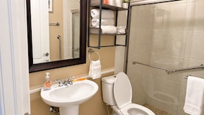 Ein Badezimmer mit weißem Waschbecken, Toilette und Duschbereich.