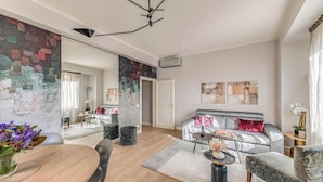 Ein modernes Wohnzimmer mit einem grauen Sofa, einem Esstisch mit Stühlen und einem Couchtisch.