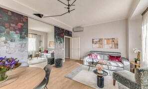 A modern living room with a grey sofa, a dining table with chairs, and a coffee table. - FLORENCE APARTMENT WITH UNFORGETTABLE PONTE VECCHIO VIEWS (Firenze)