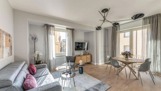 Ein modernes Wohnzimmer mit Sofa, Couchtisch und Essbereich.