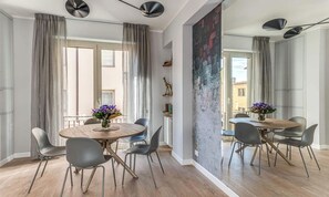 A dining area with a round table, chairs, and a vase of flowers. - FLORENCE APARTMENT WITH UNFORGETTABLE PONTE VECCHIO VIEWS (Firenze)