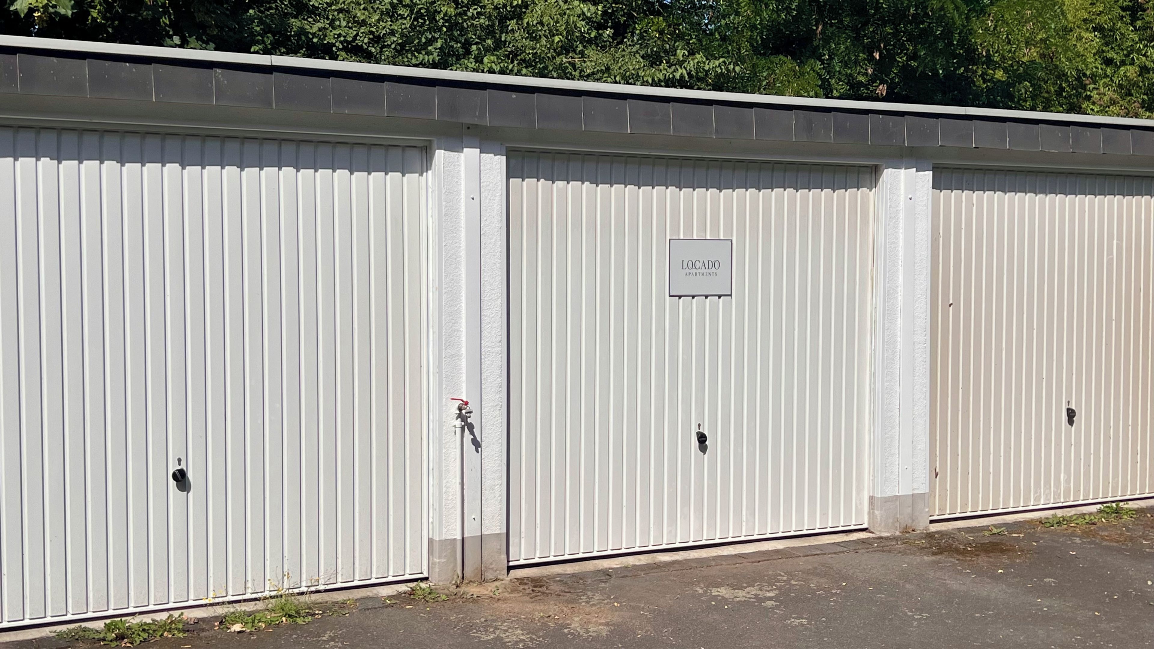 Eine Reihe weißer Gebäude aus Metall mit einem Schild, auf dem 'LOCADO APARTMENTS' steht.