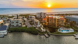A coastal resort with a swimming pool, beachfront view, and multiple buildings. - The Baycrest | Heated Pool, Beach and Bay Access (Treasure Island)