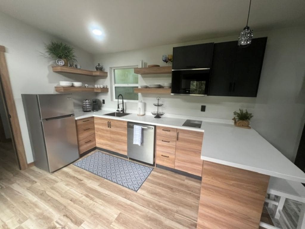 Una cocina moderna con armarios de madera, un refrigerador de acero inoxidable y un horno empotrado.