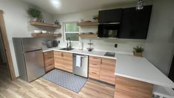 Una cocina moderna con armarios de madera, un refrigerador de acero inoxidable y un horno empotrado.
