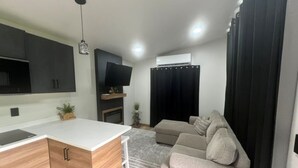 A modern living space with a kitchen, a flat-screen TV, a sofa, and a dining area. - Soothing 1-bedroom house with AC in charming Spanish Fork (Spanish Fork)