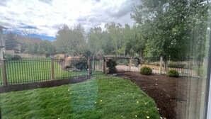 A fenced outdoor area with a grassy lawn and trees. - Soothing 1-bedroom house with AC in charming Spanish Fork (Spanish Fork)