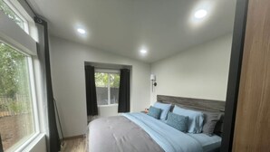A bedroom with a bed, a window, and a door. - Soothing 1-bedroom house with AC in charming Spanish Fork (Spanish Fork)