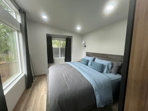 Quarto com cama, janela e porta.