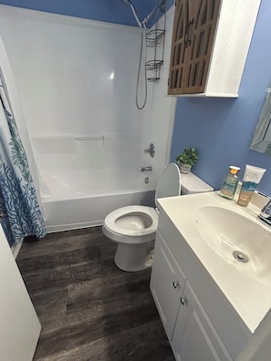 A bathroom with a bathtub, toilet, and sink. - Private Coastal Decor apartment in Saint Leonard (Saint Leonard)