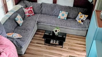 Una sala acogedora con un sofá modular, una mesita de centro y una pequeña mesita auxiliar.