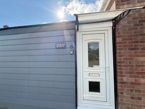 Una puerta blanca con un panel de vidrio y un letrero que dice 'THE BEACH RETREAT'.