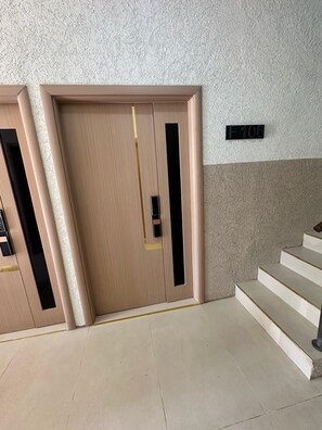 A beige door with a vertical black stripe, a small black handle, and a yellow stripe near the bottom. - Chic 1BR Island Retreat |  Paradisiac, Jamaica (Llandovery)