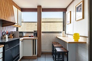A compact kitchen with a microwave, coffee maker, and wooden stools. - 3BR Near Reforma & Mexico City Historic Center (Mexico City)