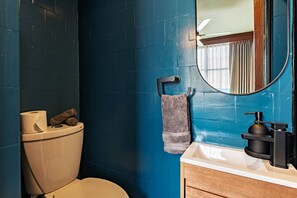 A bathroom with a toilet, a towel rack, a sink with a soap dispenser, and a mirror. - 3BR Near Reforma & Mexico City Historic Center (Mexico City)