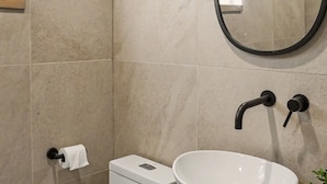 A bathroom with a white toilet, a white sink with a large bowl, and a mirror above the sink. - Nordic Forest Chalet near Mont Tremblant | 32+ Days | Pet Friendly! (Lac-Supérieur)