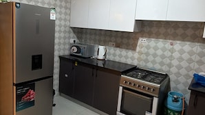 Una cocina con refrigerador, estufa y armarios.