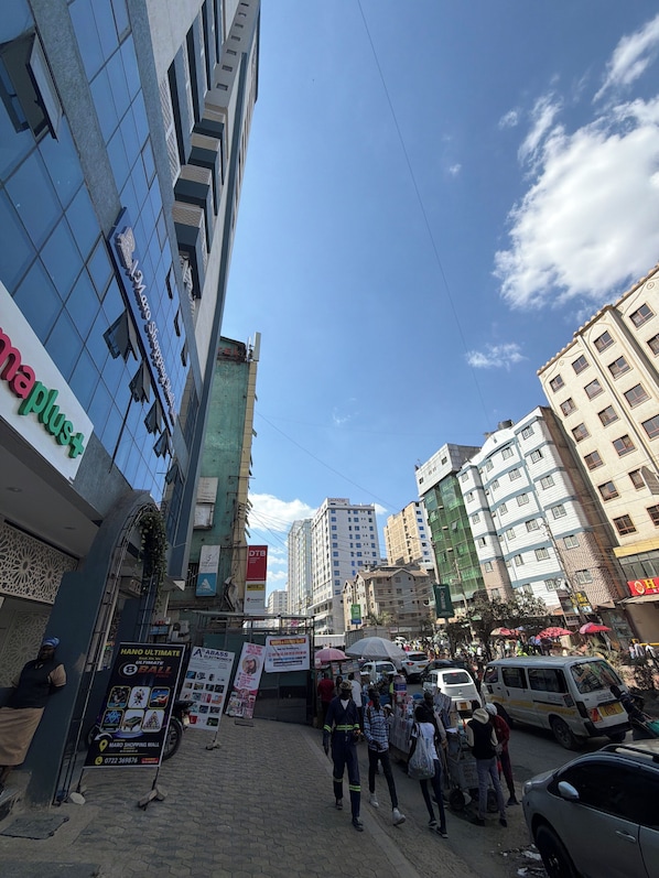 Una calle urbana concurrida con peatones, vehículos y edificios comerciales.