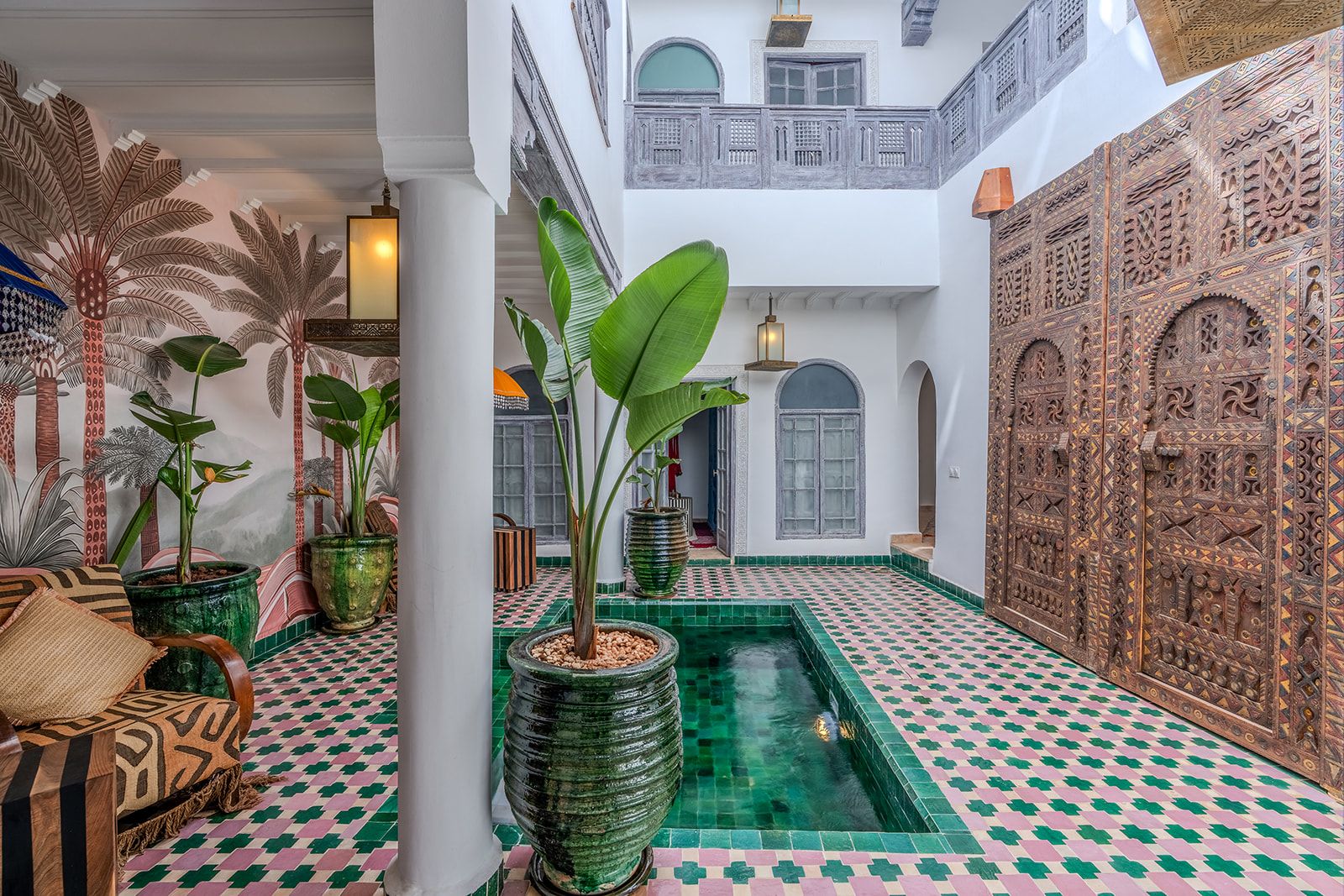 Un intérieur spacieux agrémenté d’un élément aquatique central, d’un revêtement de sol à motifs et de panneaux muraux décoratifs.