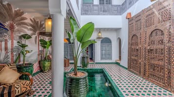 Un intérieur spacieux agrémenté d’un élément aquatique central, d’un revêtement de sol à motifs et de panneaux muraux décoratifs.