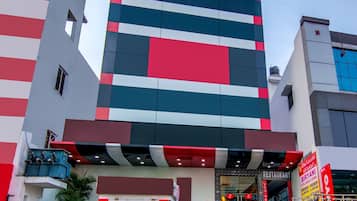 Un immeuble à étages doté d’une architecture moderne, caractérisé par une bande verticale bien visible sur la façade.