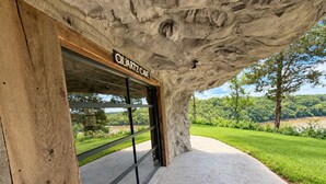 Entrada de um edifício com fachada de pedra natural e uma placa com a inscrição 'QUARTZ CAVE'.