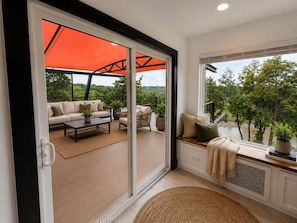 A modern interior with a sliding glass door leading to an outdoor patio area. - Altura Tower - With a View (Lancaster)