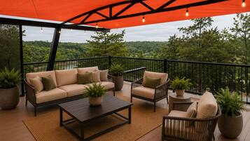 An outdoor patio with a sofa, chairs, a coffee table, and potted plants.