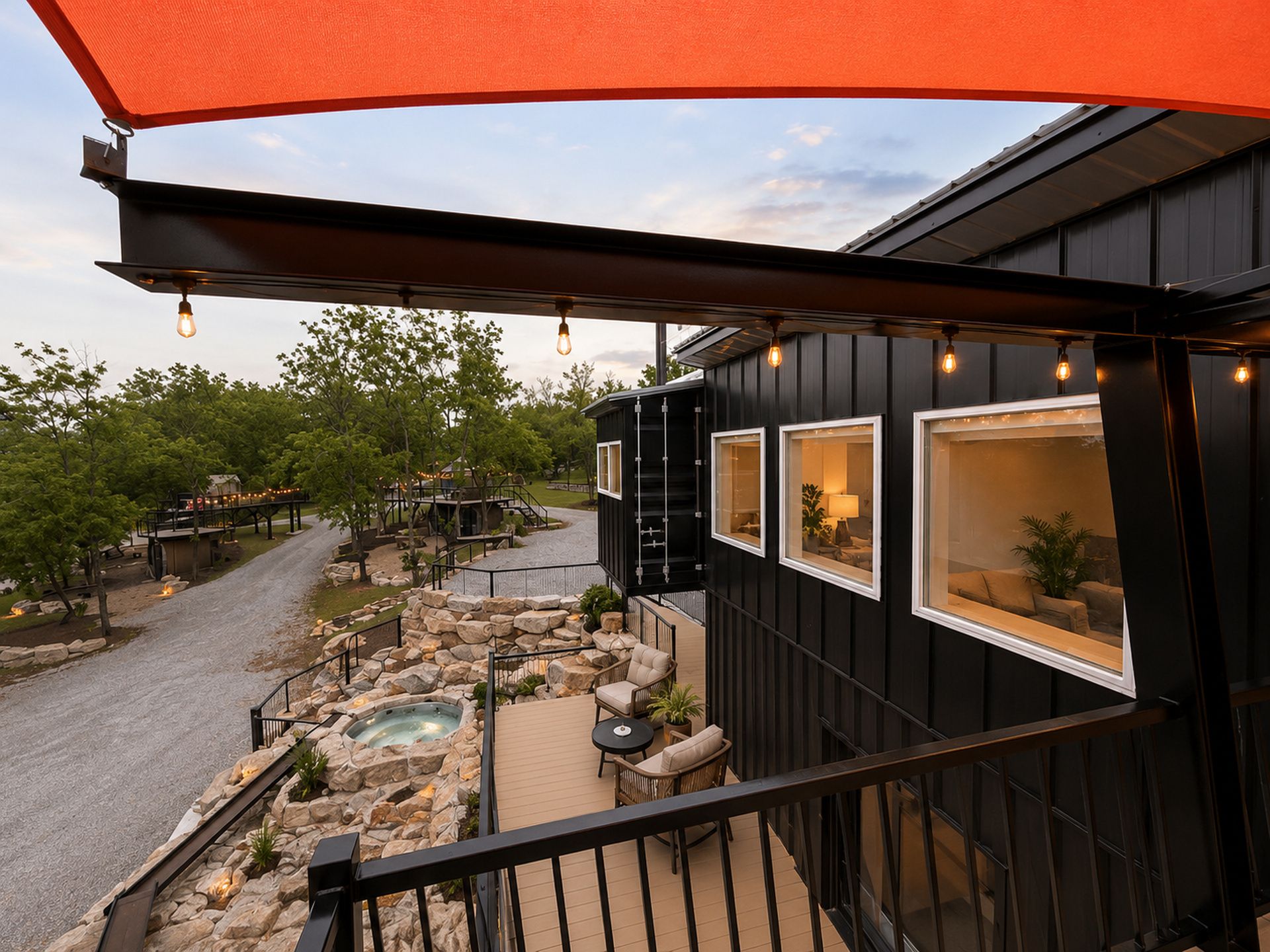 A deck with a hot tub, outdoor seating, and a view of a building with large windows.