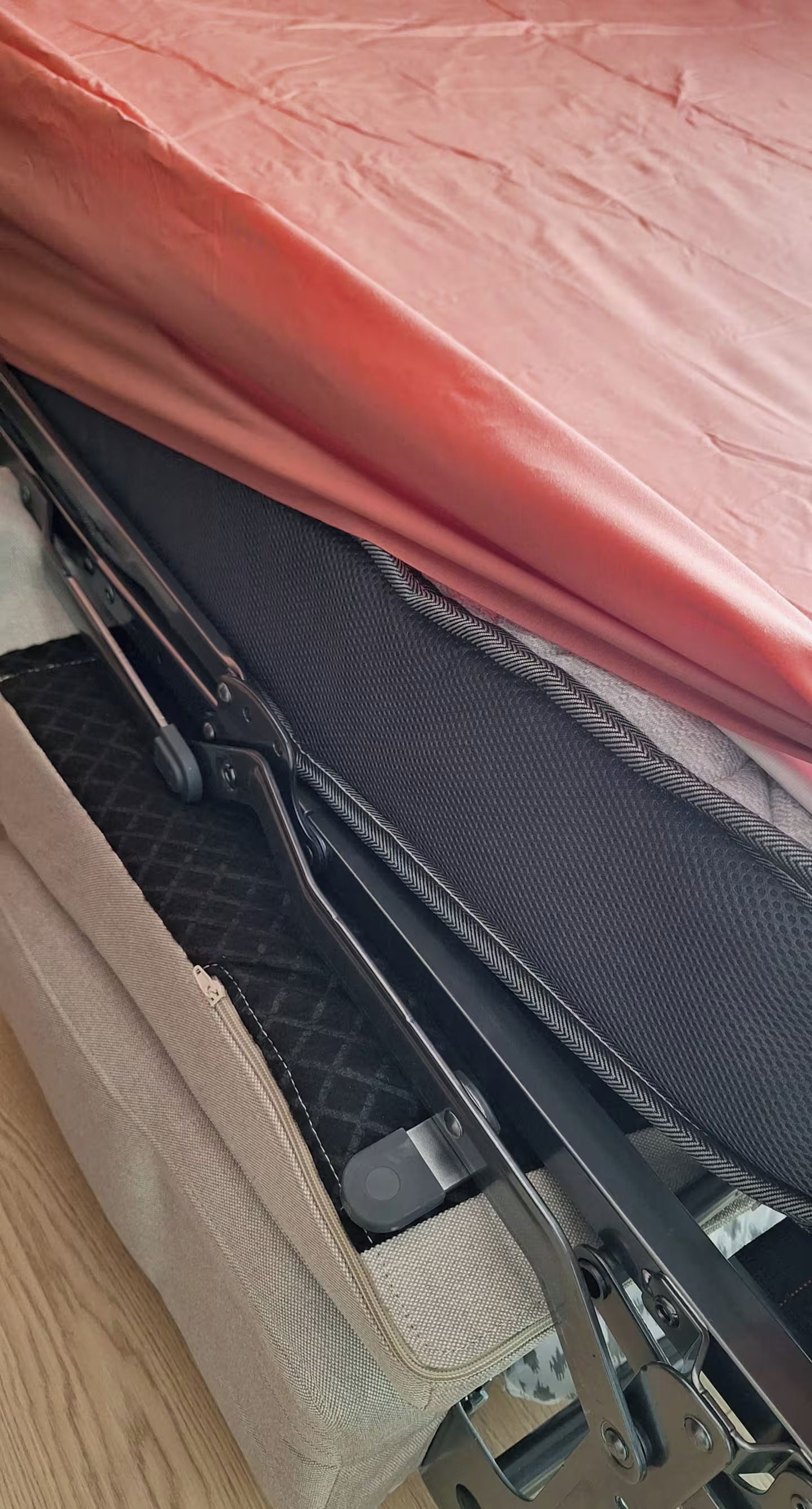 Un letto con una coprimacchina rossa e un poggiatesta nero con motivo a zig-zag.