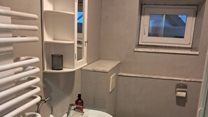 Ein Badezimmer mit Waschbecken, Toilette und Handtuchhalter.