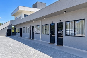 Un edificio moderno con techo plano, ventanas amplias y un camino pavimentado.