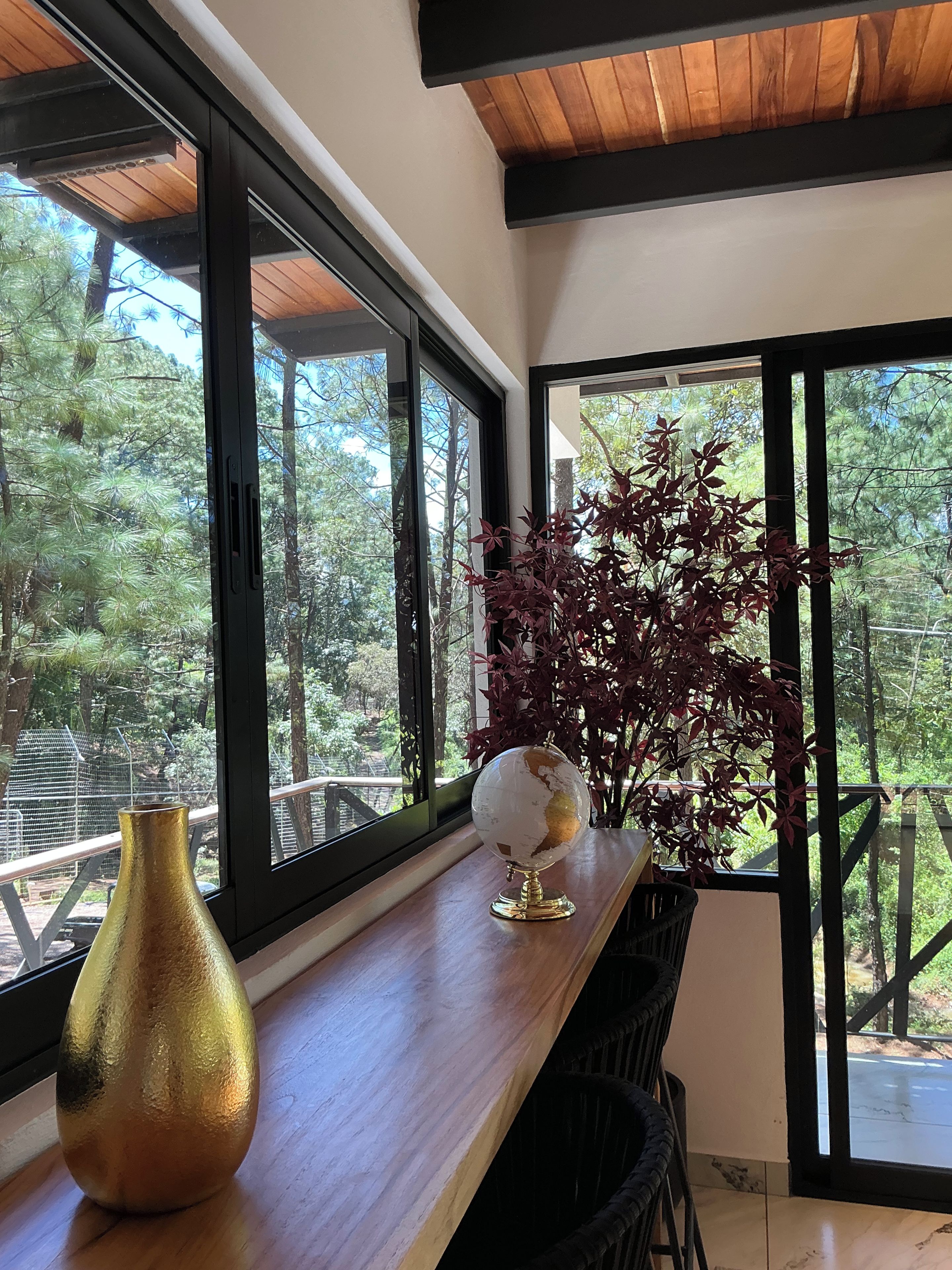 A room with a wooden table, a globe, and a vase.
