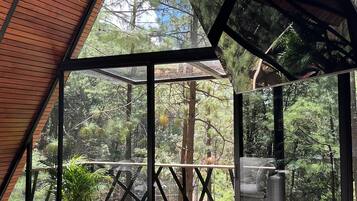 Un intérieur moderne avec une grande baie vitrée donnant sur une terrasse en bois et un espace extérieur.