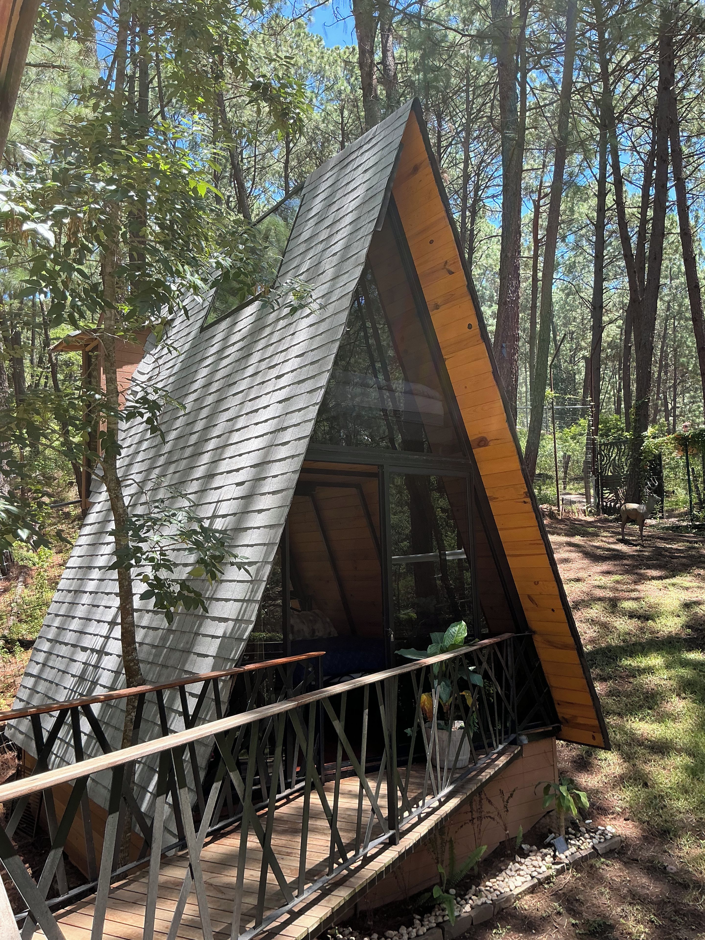 A small cabin with a sloped roof, a wooden deck, and a glass door.