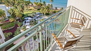 A balcony with a view of a resort area, including palm trees and a pool. - Studio Deluxe, Ocean View, at Wyndham Rio Mar in Puerto Rico, on Golf Course! (Río Grande)