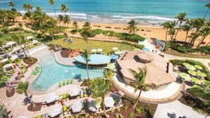 A resort with a pool, beach, and palm trees. - Studio Deluxe, Ocean View, at Wyndham Rio Mar in Puerto Rico, on Golf Course! (Río Grande)